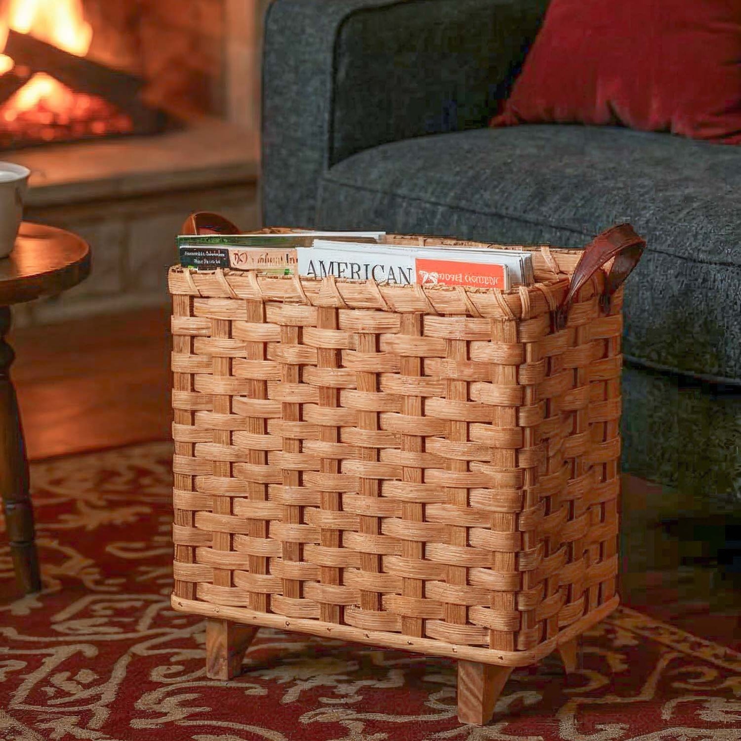 Amish handwoven slim wicker magazine basket with wooden legs holding magazines in a living room